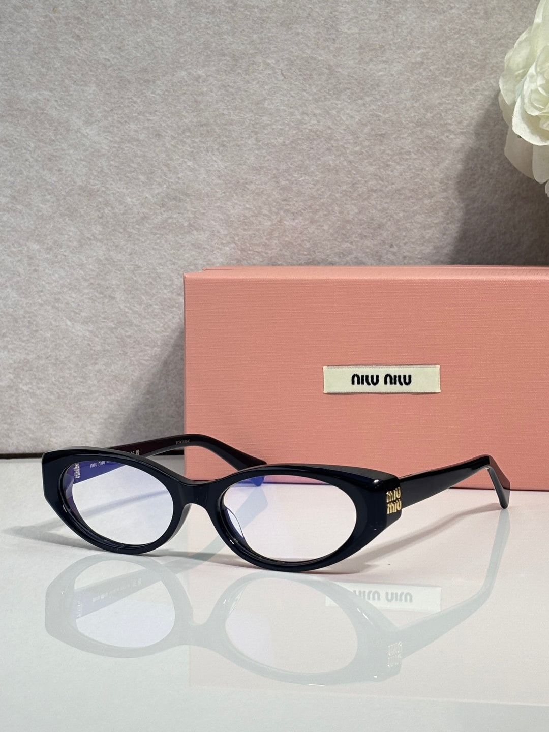 MiuMiu eyeglasses with dark glossy frames, round rectangular profile and clear front lenses