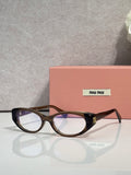 MiuMiu eyeglasses with dark tortoiseshell frames and clear lenses, logo temple detail
