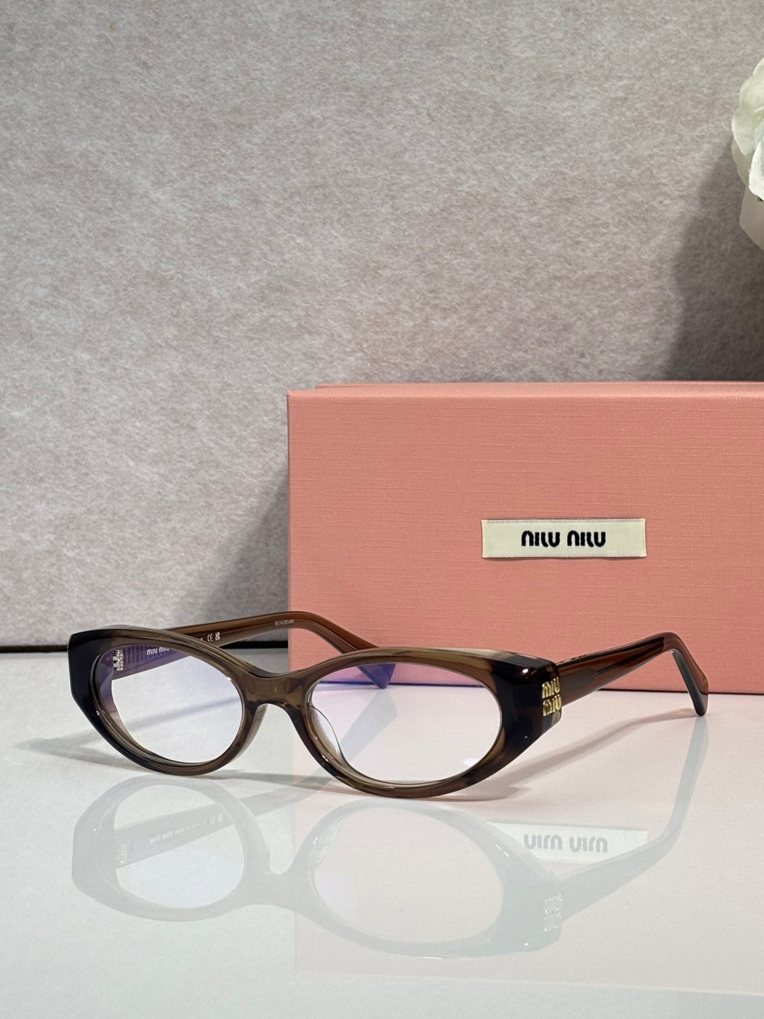 MiuMiu eyeglasses with dark tortoiseshell frames and clear lenses, logo temple detail