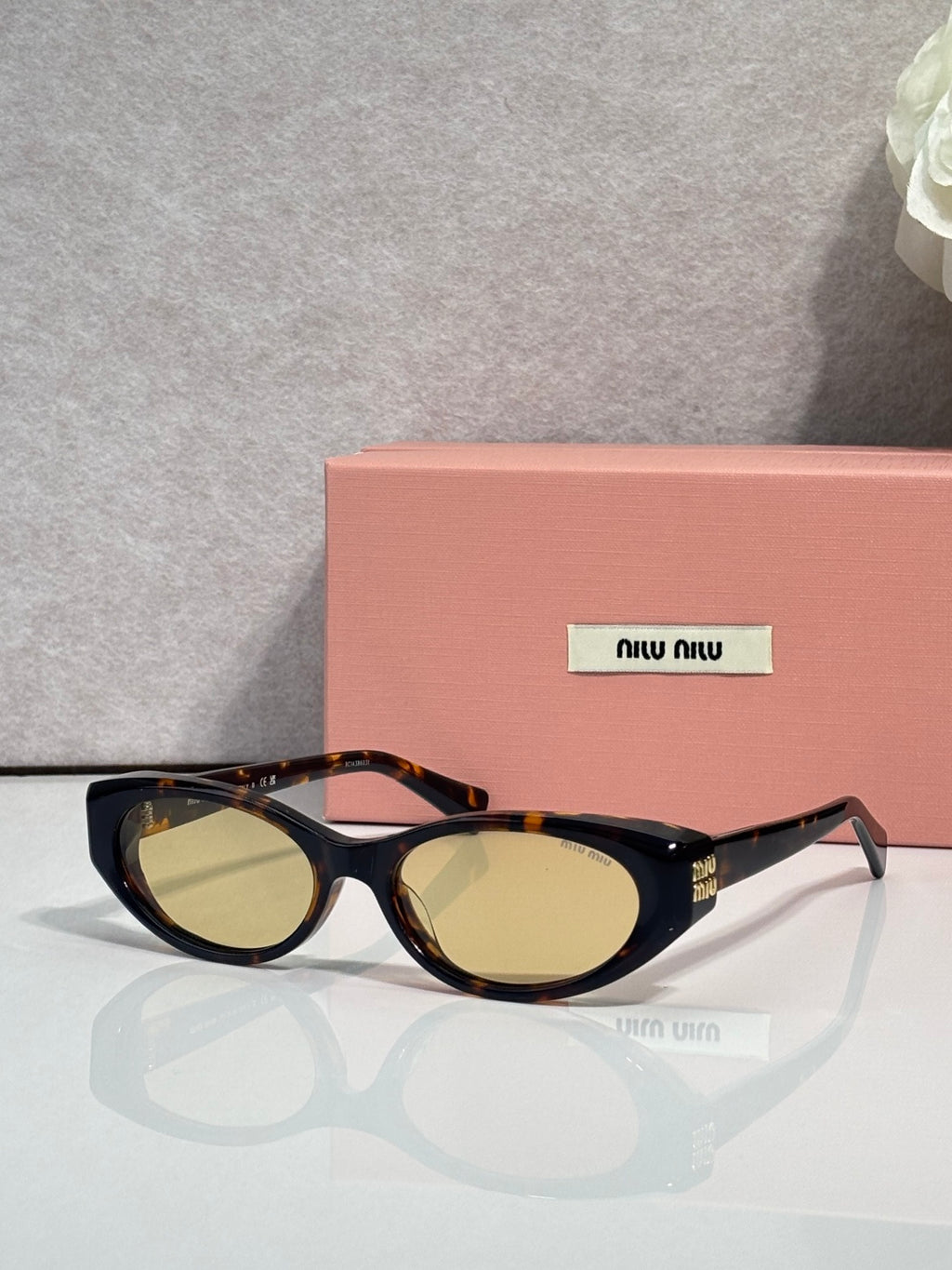 MiuMiu glasses with dark frames and gold-tinted oval lenses