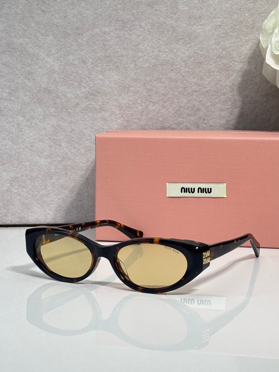 MiuMiu glasses with dark frames and gold-tinted oval lenses