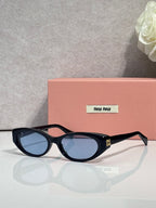 MiuMiu glasses with dark frames and blue-tinted oval lenses