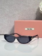 MiuMiu glasses with dark oval frames and dark tinted lenses