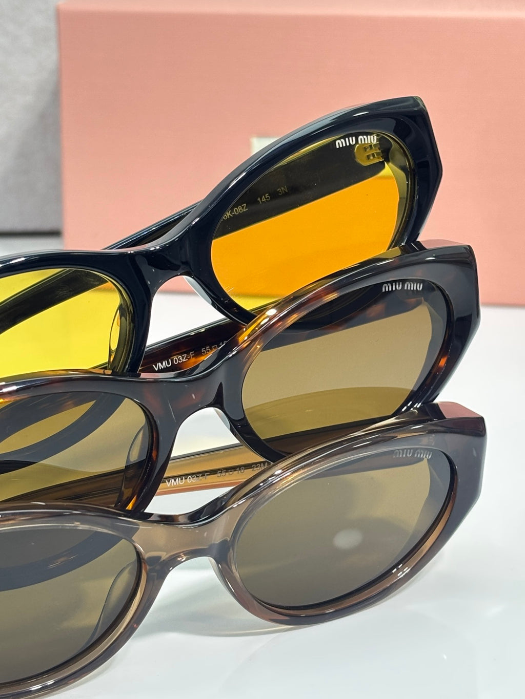 MiuMiu glasses close-up with dark frames and yellow-tinted lenses