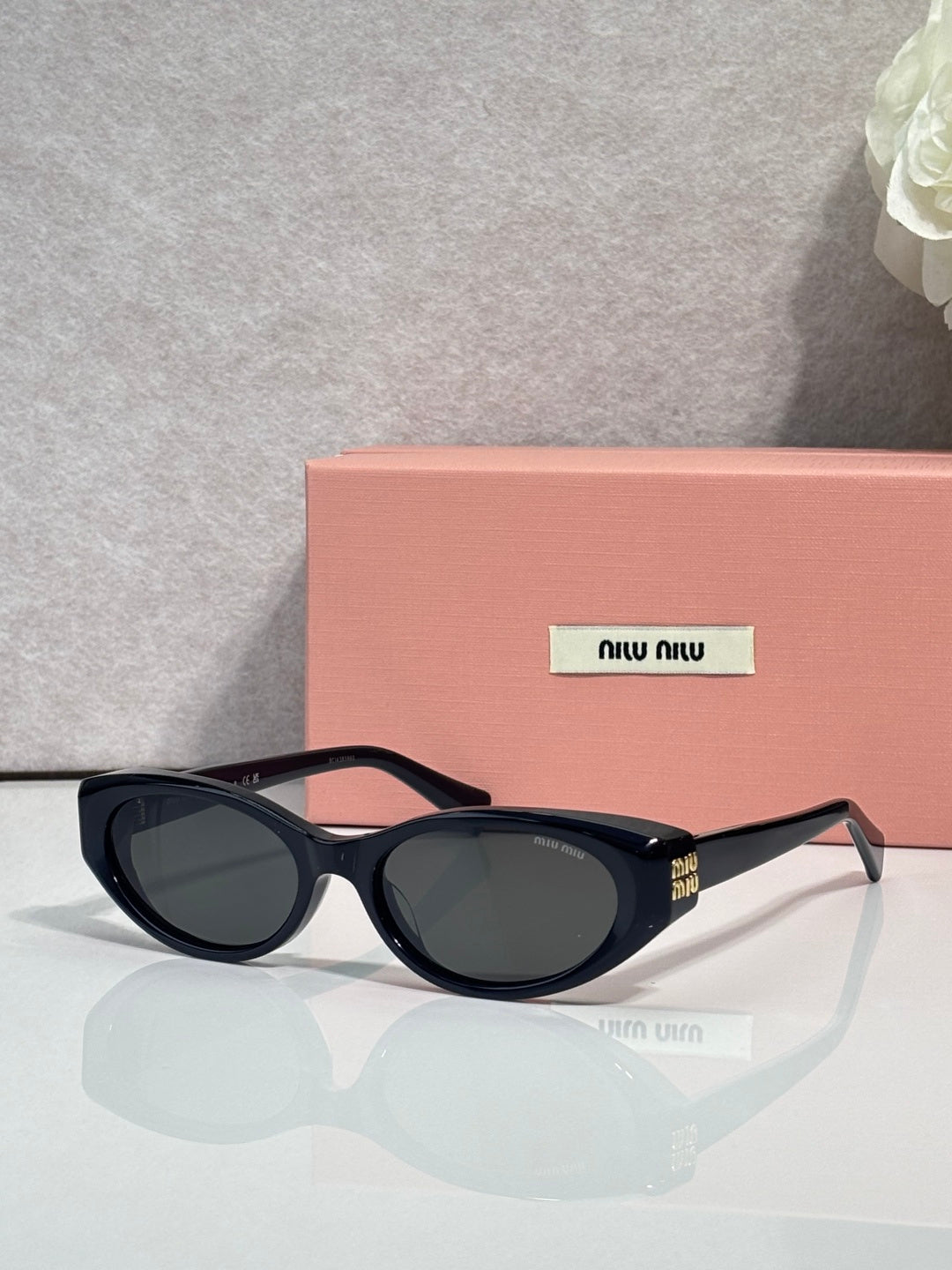 MiuMiu glasses with black frames and blue-tinted oval lenses