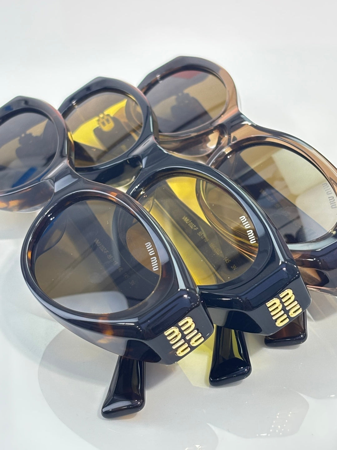 Navy sunglasses with yellow lenses and 'miu miu' temple branding