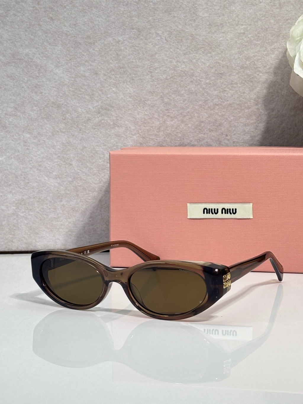 Brown cat-eye sunglasses with dark lenses and gold logo hardware