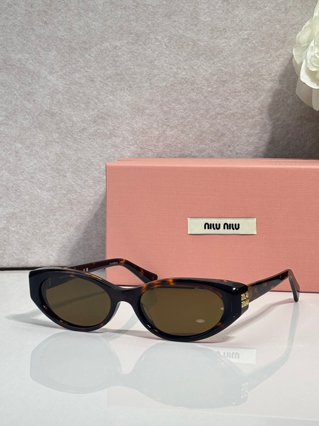 MiuMiu cat-eye sunglasses with dark lenses and black acetate frames