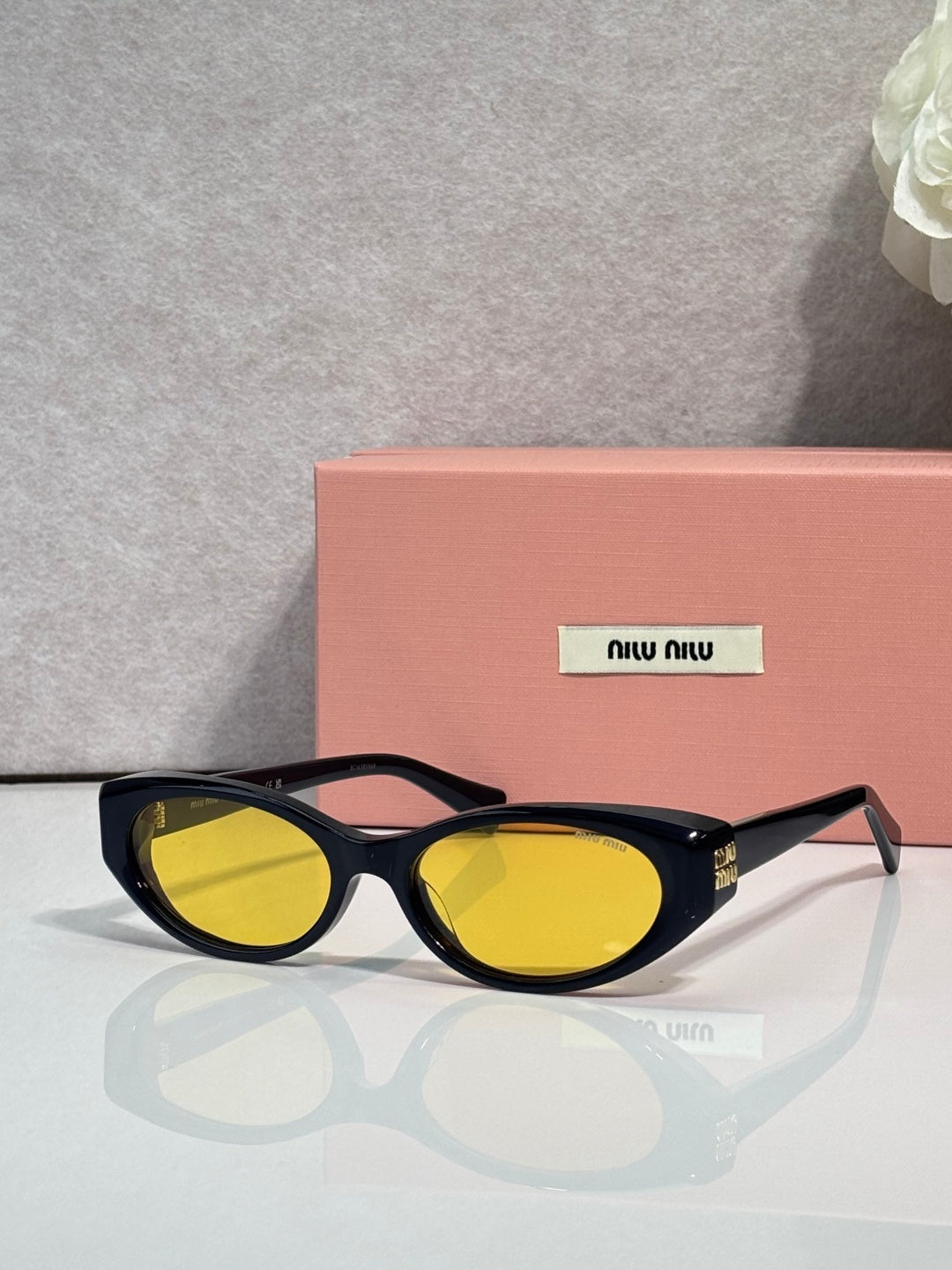Cat-eye sunglasses with yellow lenses and dark frames with gold hardware