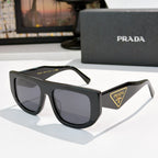 Prada sunglasses with dark frames and gray tinted lenses, triangular Prada logo on temple.
