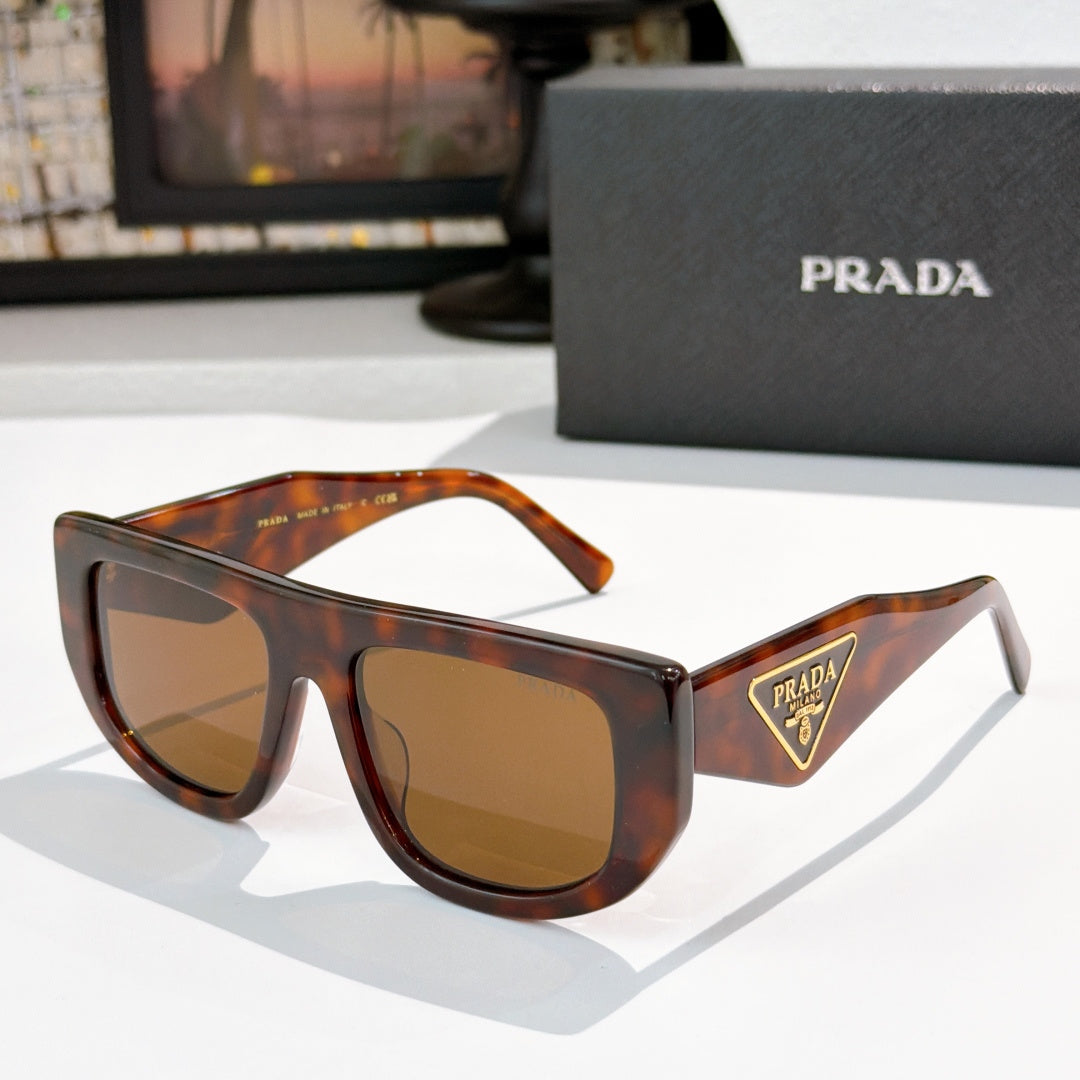 Prada sunglasses with tortoiseshell frames and amber tinted lenses, triangular logo on temple.