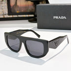 Prada sunglasses with black frames and dark tinted lenses, triangular logo on temple.