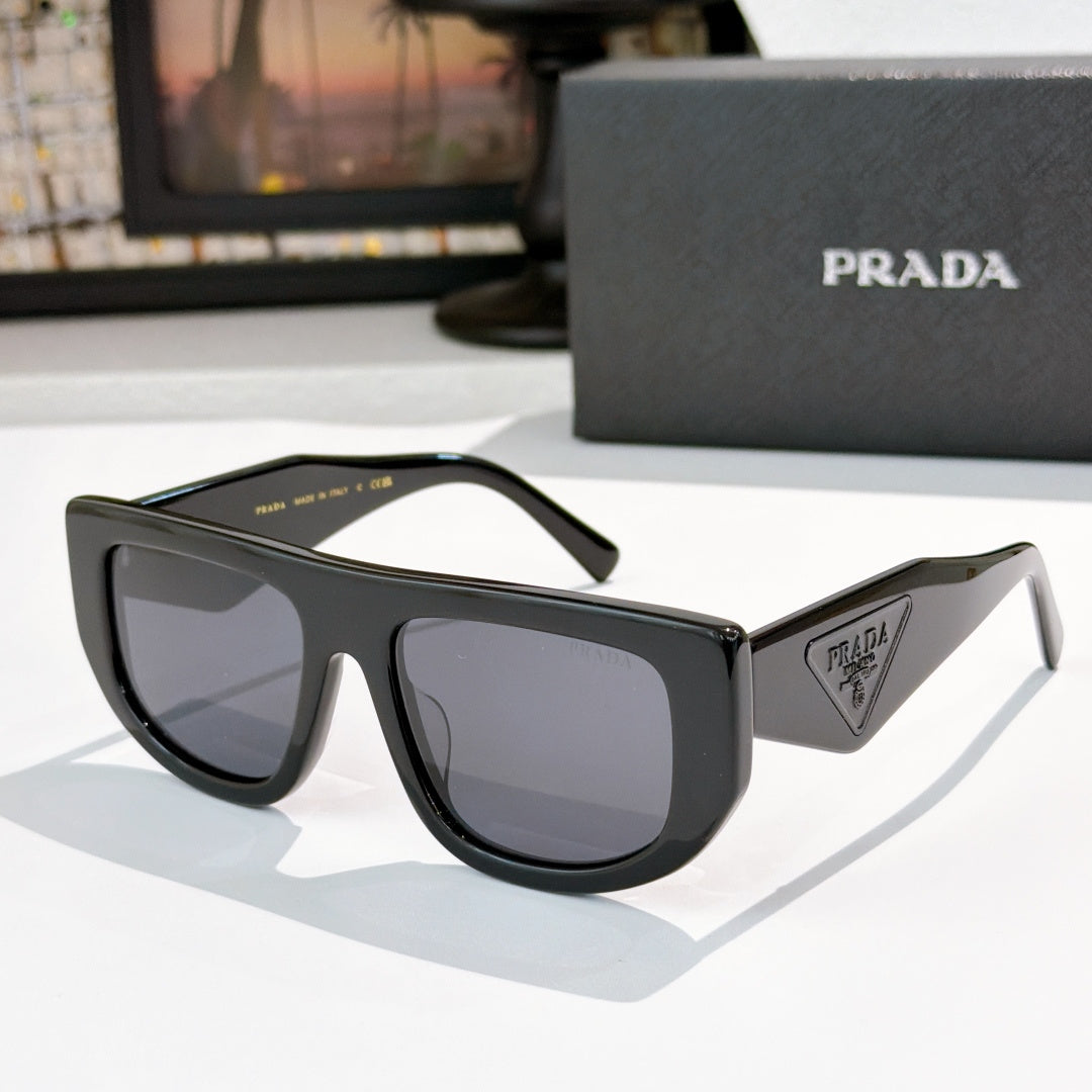 Prada sunglasses with black frames and dark tinted lenses, triangular logo on temple.