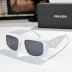 Prada sunglasses with white frames and dark tinted lenses, triangular logo on temple.