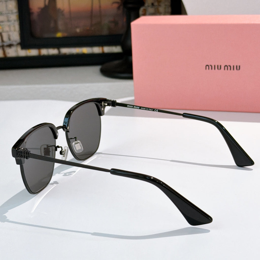 Sunglasses with dark lenses and black frame, gold-toned bridge, logo detail on temples