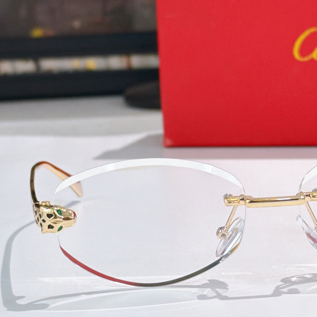 Cartier round eyeglasses with gold frames, clear lenses, leopard temple detail.
