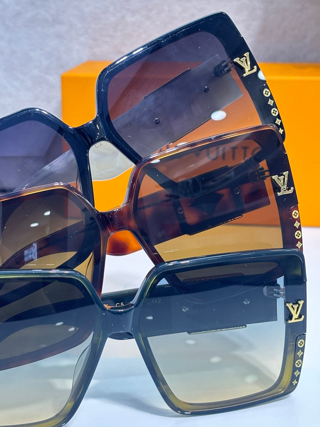 Louis Vuitton sunglasses, dark blue frames, reflective tinted lenses, LV monogram detailing
