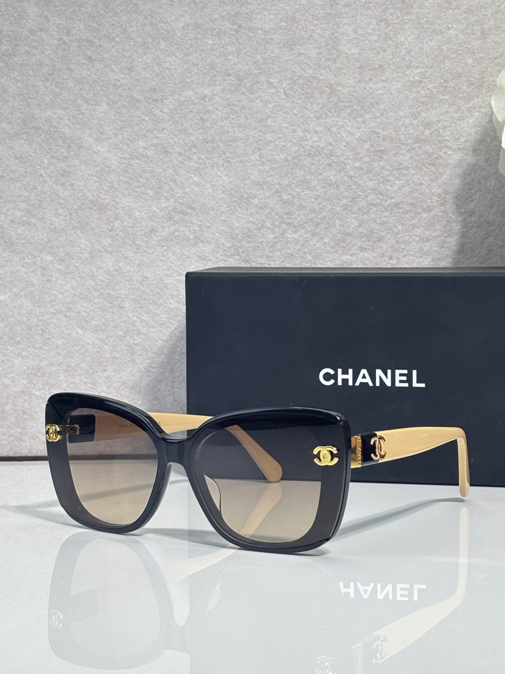 Chanel sunglasses with dark blue frames and beige temples, gradient lenses