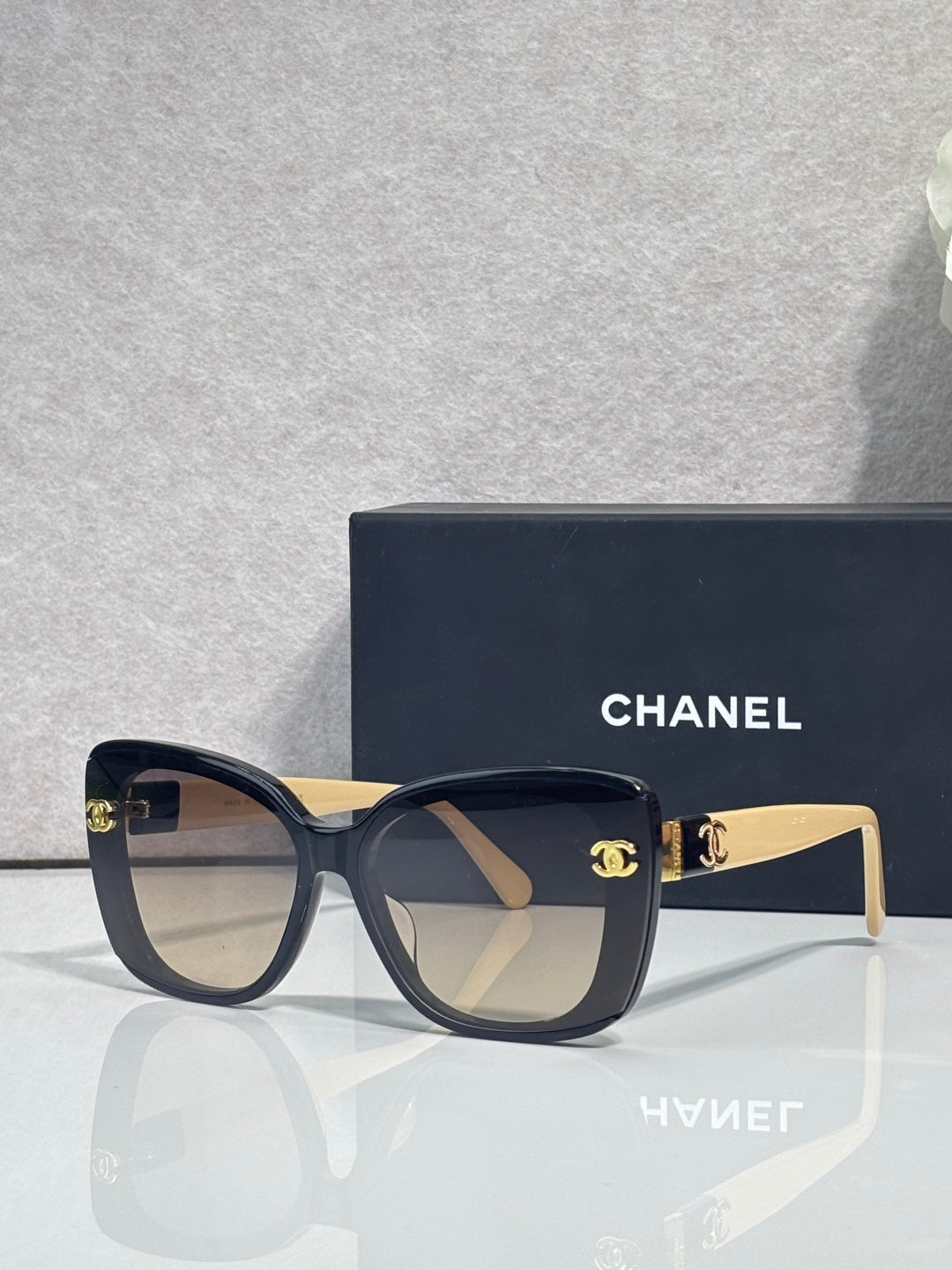 Chanel sunglasses with dark blue frames and beige temples, gradient lenses