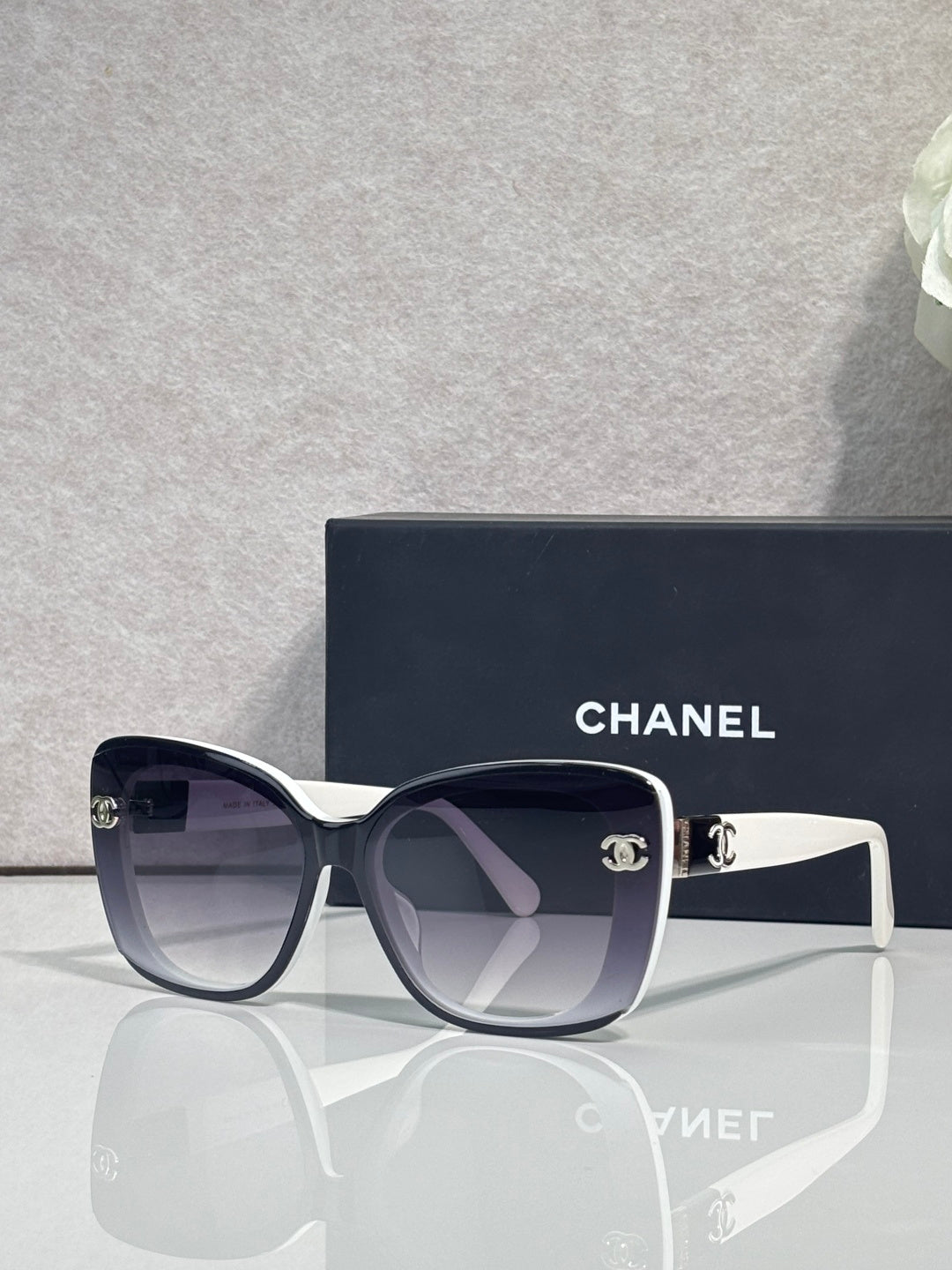 Chanel sunglasses with dark frames and light gray temples, gradient lenses