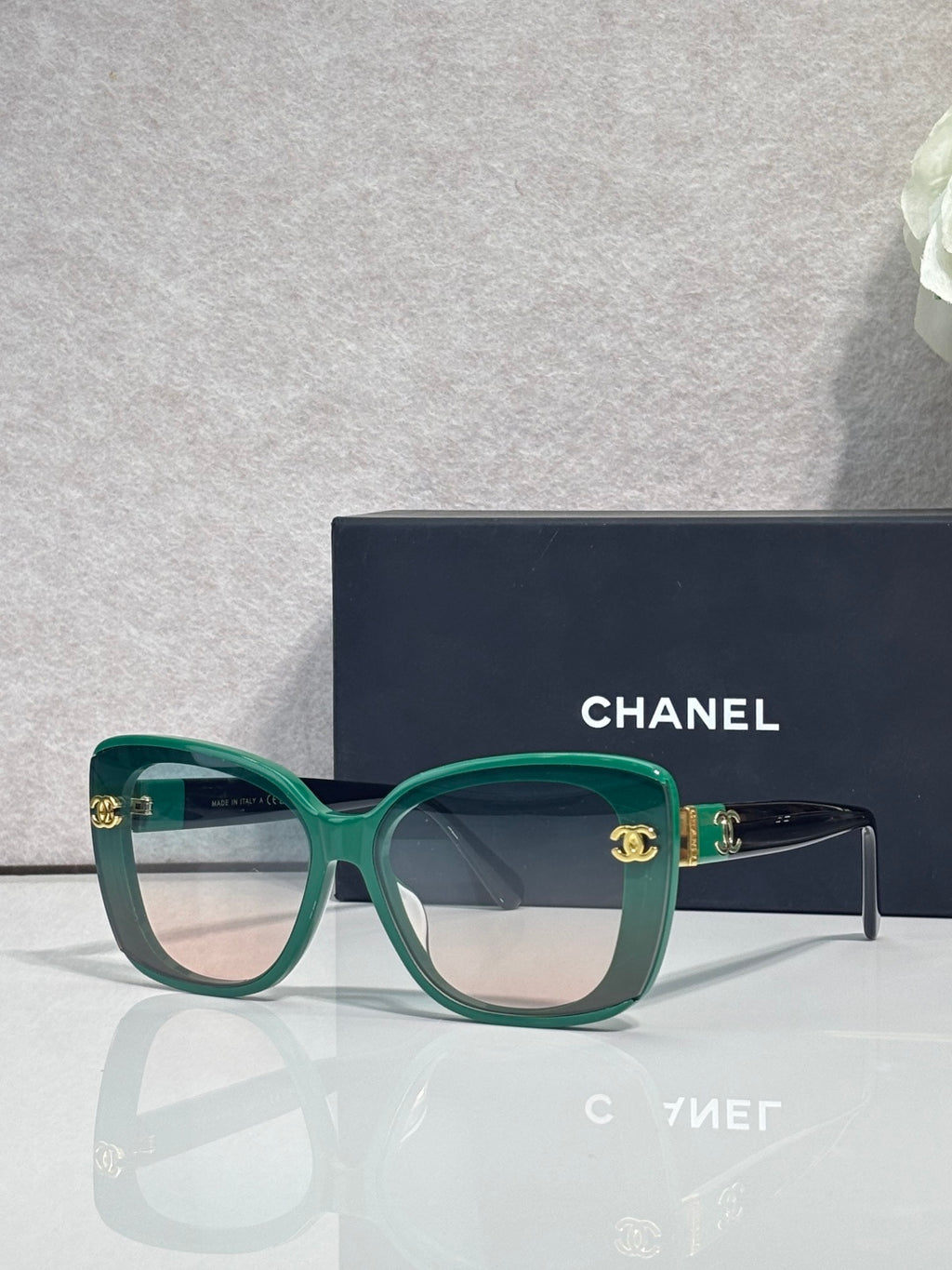 Chanel sunglasses with green frames and dark temples, gradient lenses
