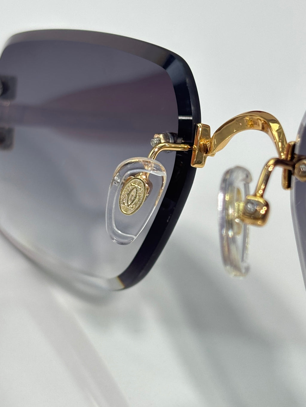 Cartier eyeglass frame close-up with gold-tone hinge and dark-tinted lens