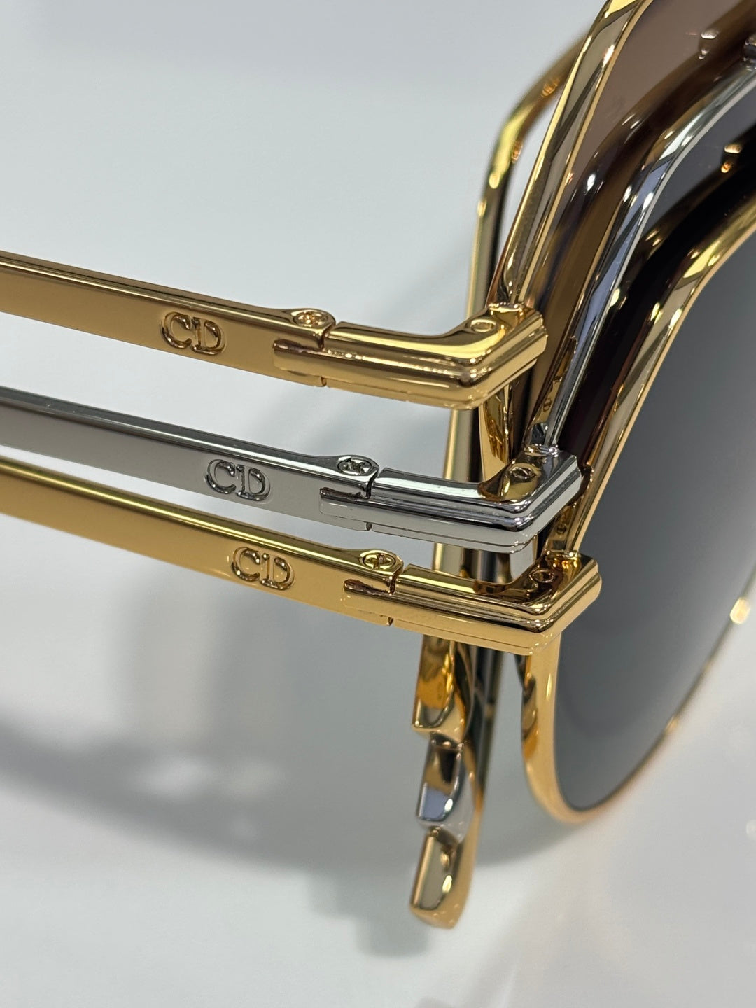 Dior sunglasses close-up: engraved CD temple details in gold and silver