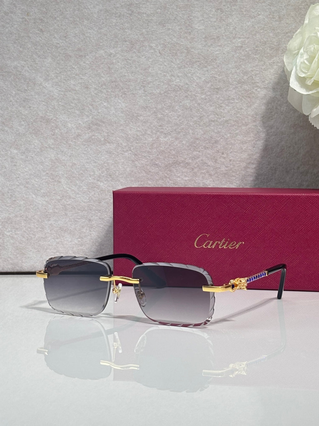 Cartier glasses with gold metal frame, dark blue tinted lenses, and thin black temple arms