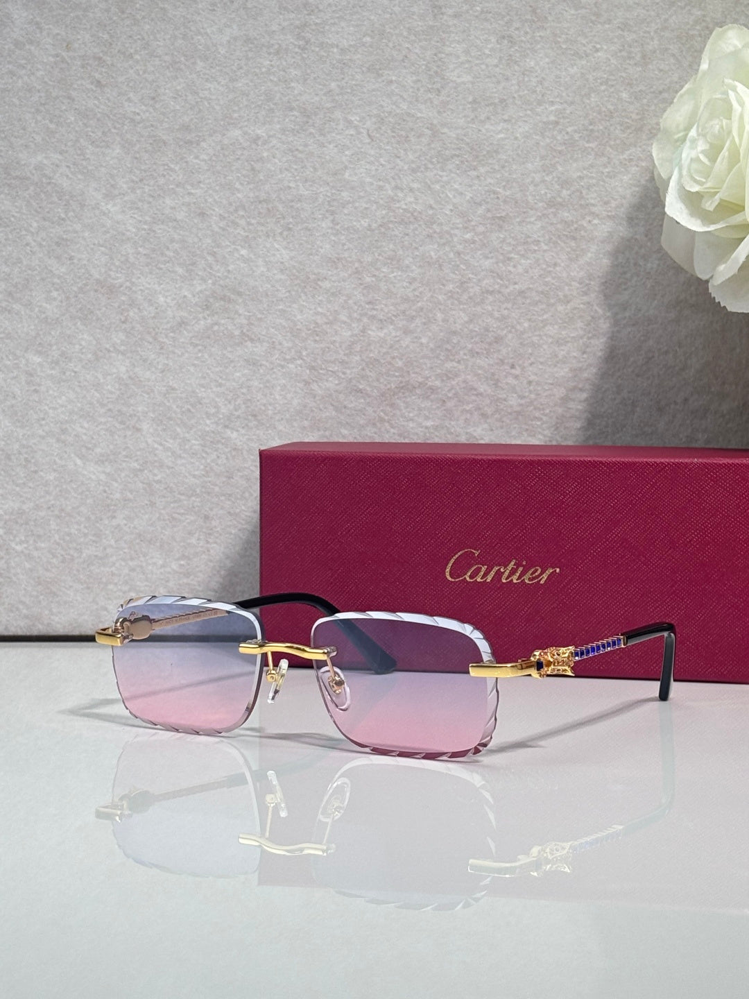 Cartier glasses with gold metal frame and pink tinted lenses, slim black temple arms