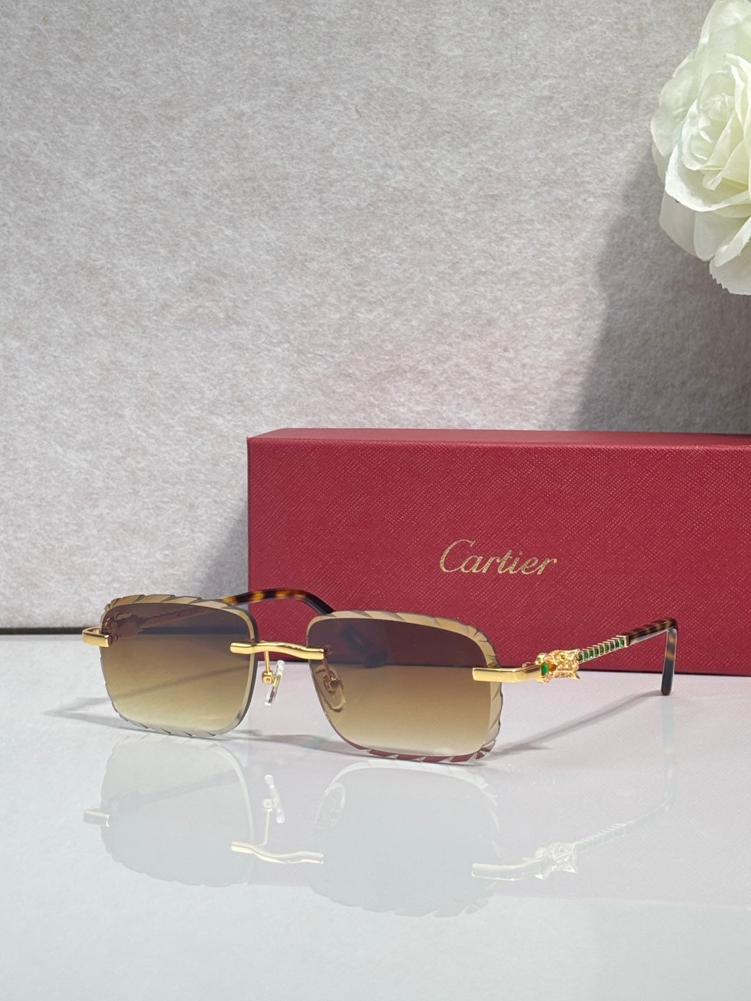 Cartier glasses with gold metal frame, brown tinted lenses, and thin black temple arms