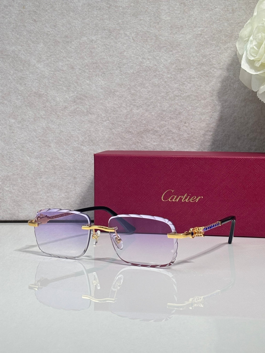 Cartier glasses with gold metal frame, light purple tinted lenses, and thin black temple arms