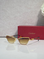 Cat-eye glasses with gold frame and dark temples, lightly tinted lenses, decorative gold temple crest