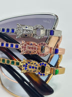 Glasses close-up with jeweled frame details, blue and multi-color stones on metal temples