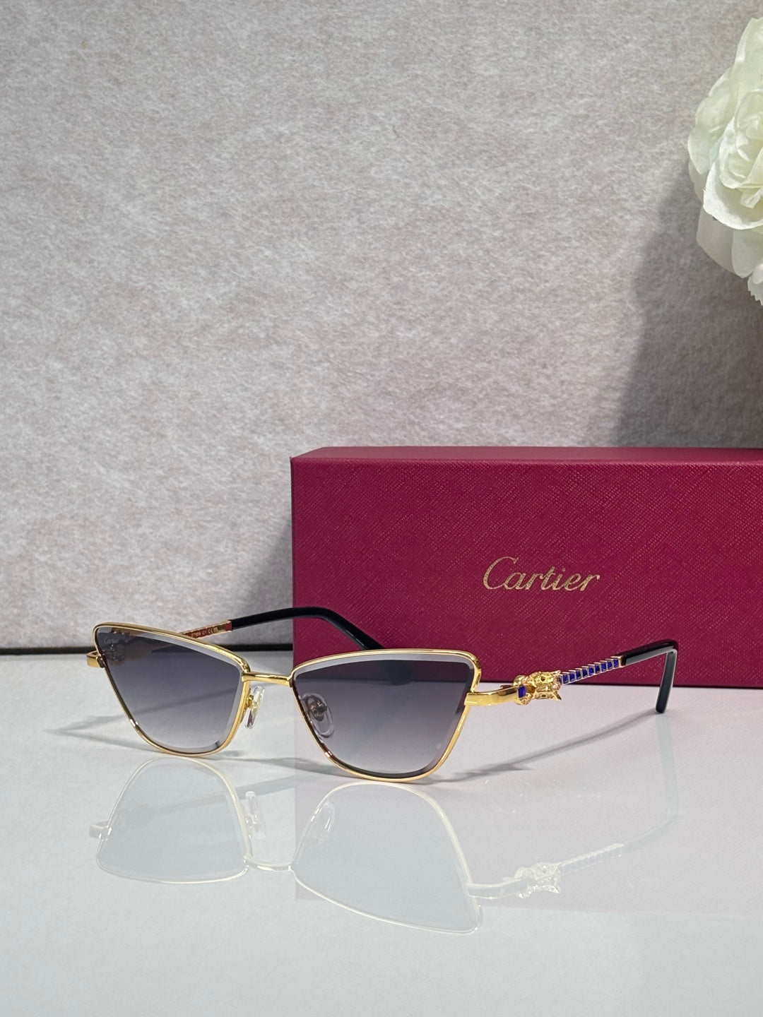 Cat-eye glasses with dark frame and gold-tone accents, tinted lenses and ornate temple piece