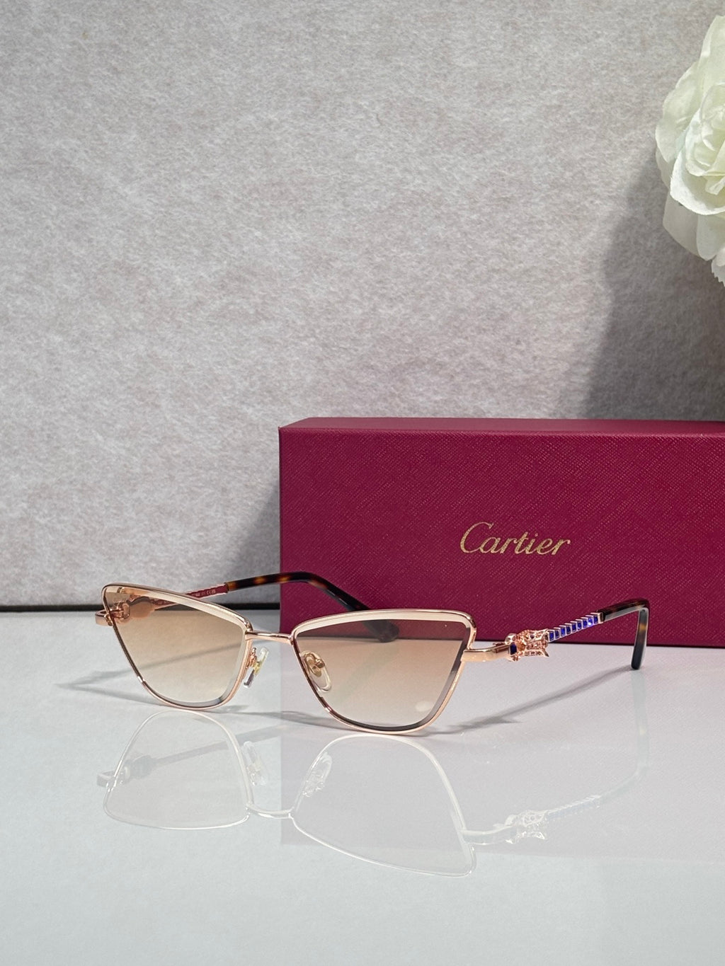 Cat-eye glasses with gold-tone frame and dark temples, light tinted lenses, ornate temple detail