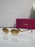 Cartier glasses with gold-tone frame and amber-tinted lenses, gold temple detail.