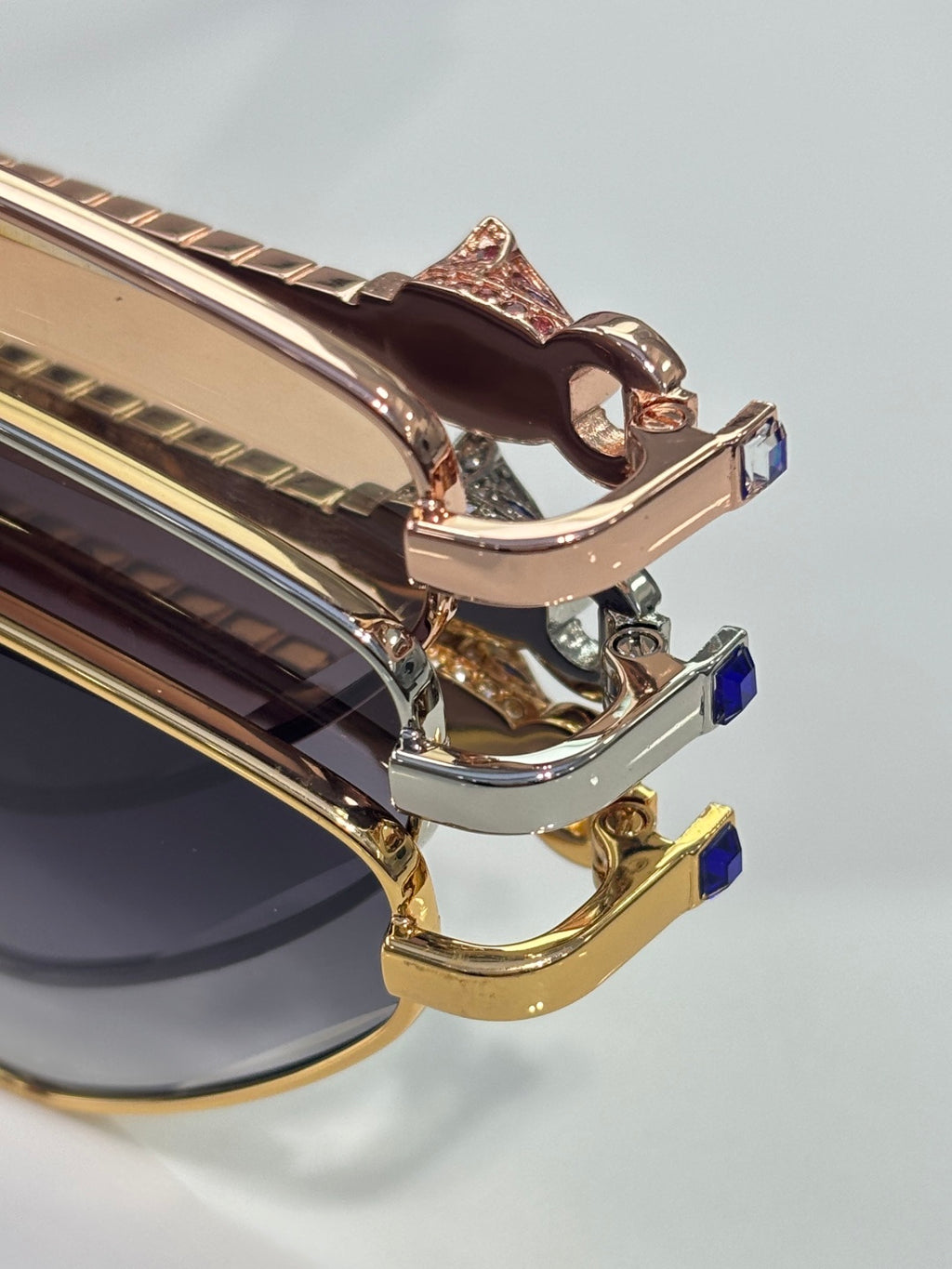 Cartier glasses close-up of gold-tone rims, metal hinge, and blue accent detail.