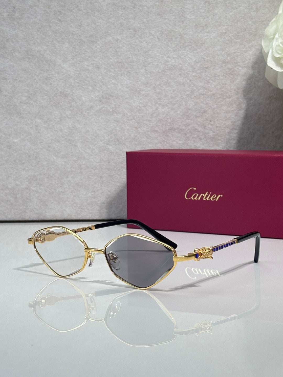 Cartier glasses with gold-tone frame, dark gray lenses, and black temples.
