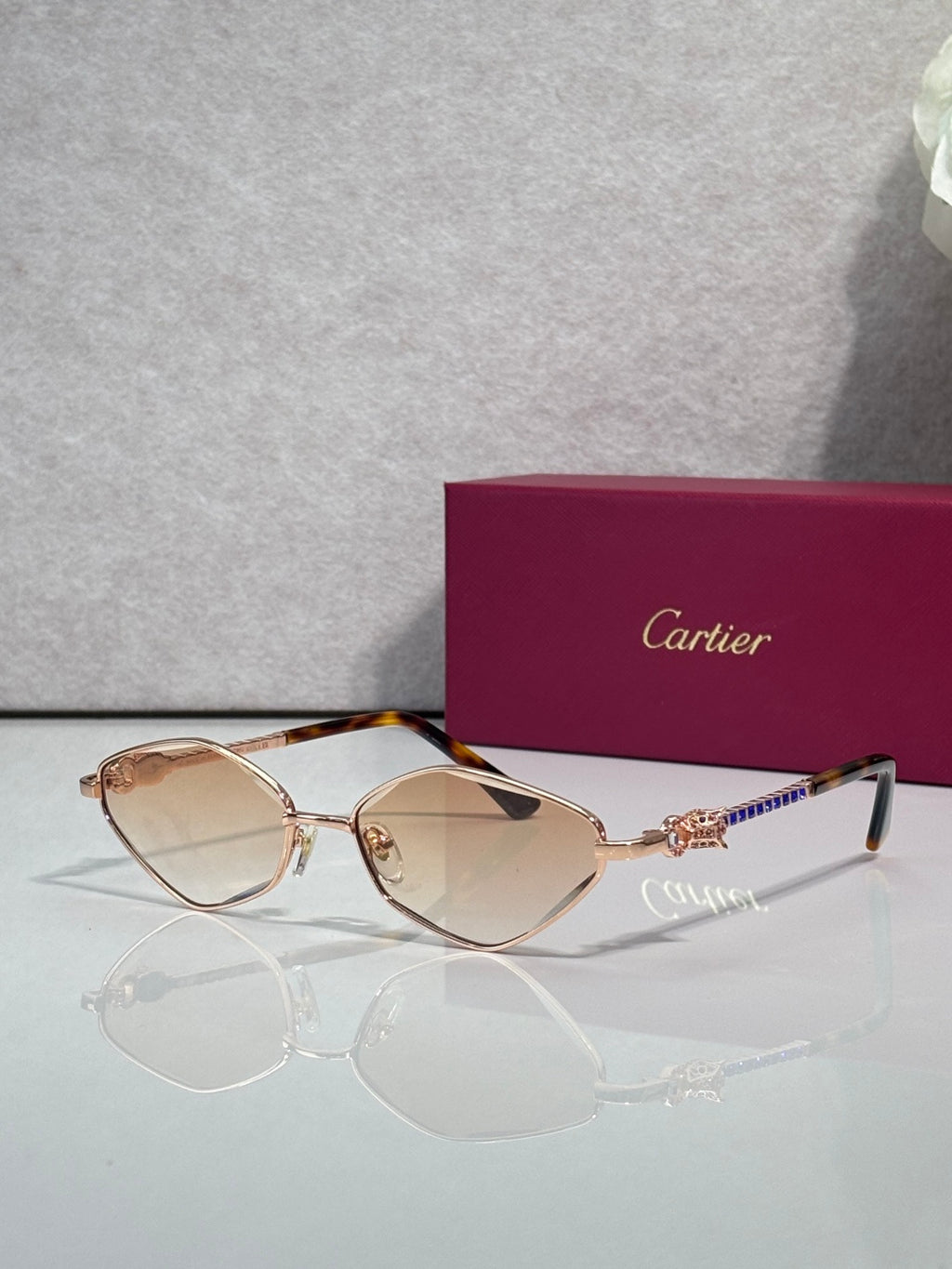 Cartier glasses with rose-gold tone frame and amber lenses, with decorative temple.