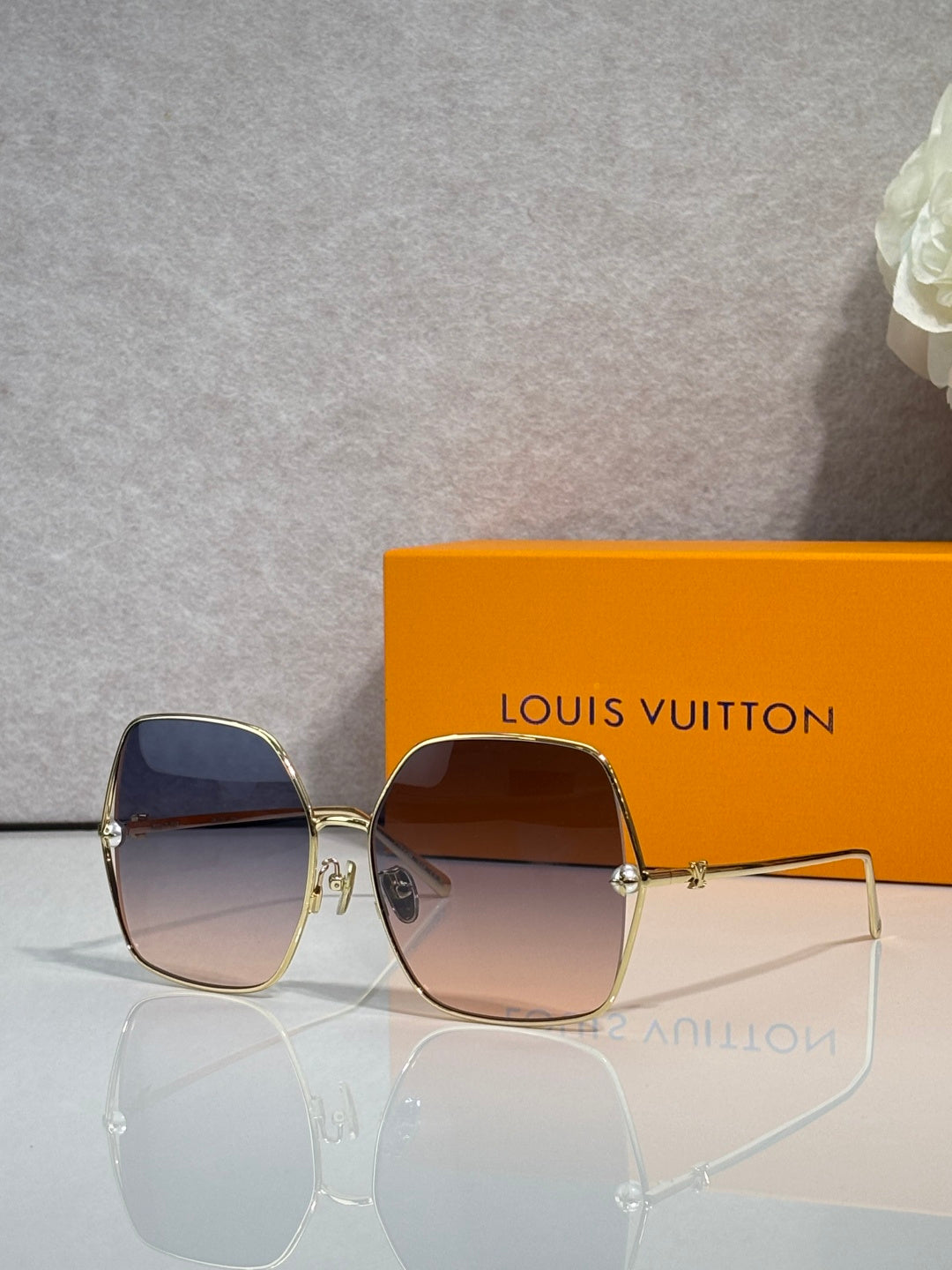 Louis Vuitton square sunglasses with dark tinted lenses and gold-tone frame