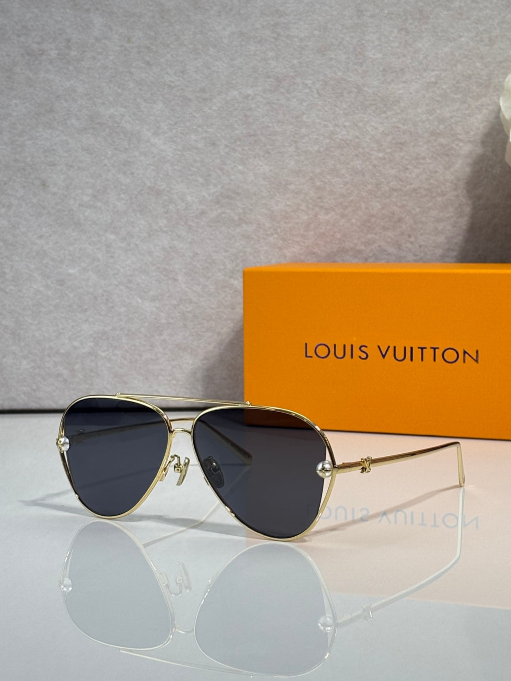 Louis Vuitton sunglasses with navy tinted lenses and gold metal frame