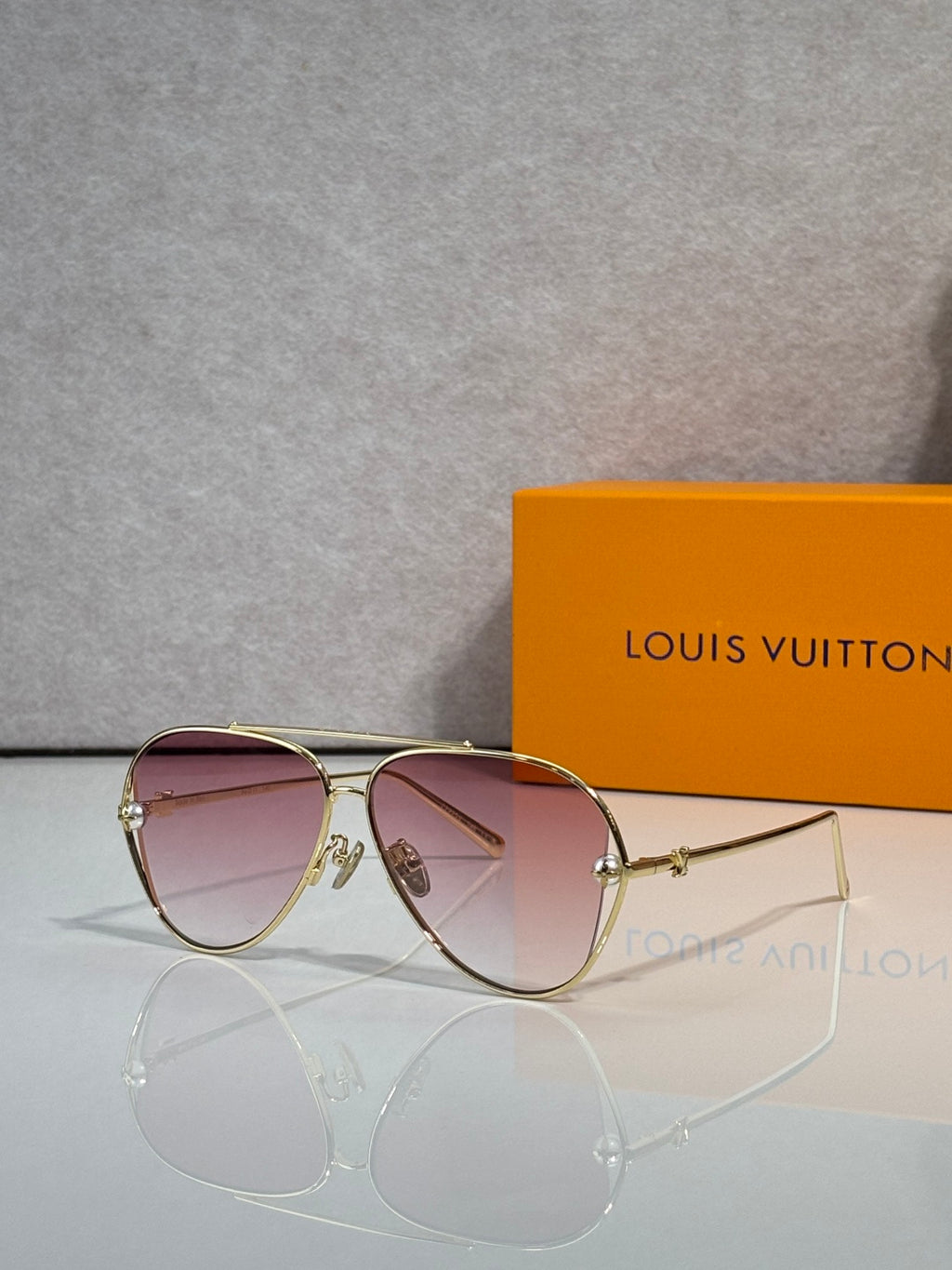 Louis Vuitton sunglasses with pink tinted lenses and gold-tone metal frame