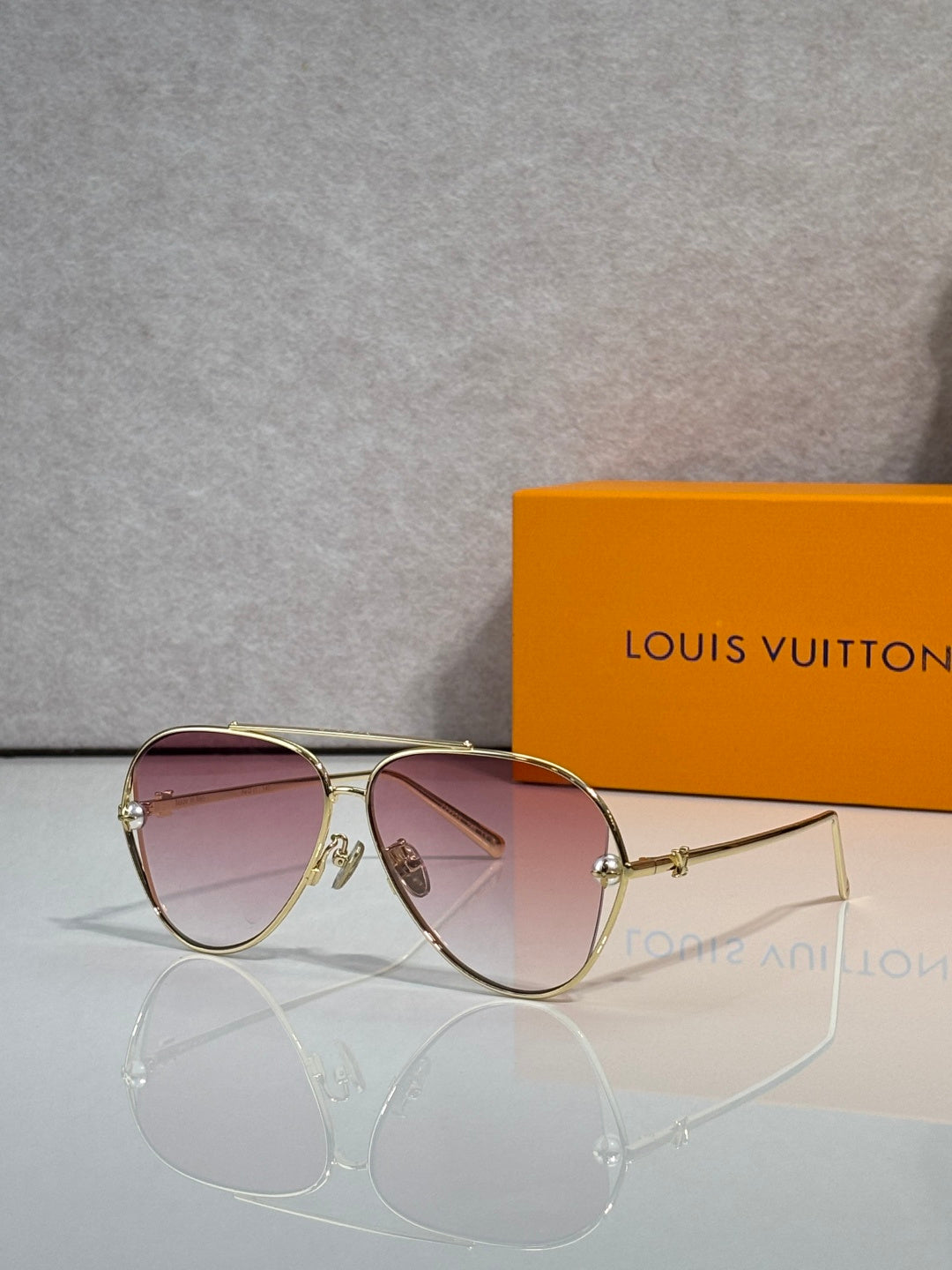 Louis Vuitton sunglasses with pink tinted lenses and gold-tone metal frame