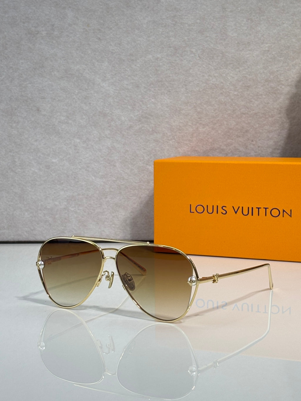 Louis Vuitton sunglasses with brown tinted lenses and gold metal frame