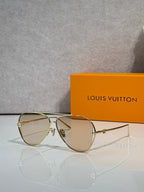 Louis Vuitton sunglasses with beige tinted lenses and gold metal frame, side angle