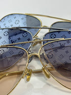 Louis Vuitton sunglasses close-up with blue monogram-pattern lenses and gold frame