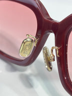Dior burgundy eyeglass frame close-up with gold hinge hardware