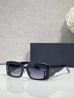 Dior rectangular sunglasses with dark lenses, glossy navy frame, gold star accents