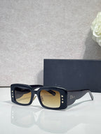 Dior rectangular sunglasses with amber-tinted lenses, navy frame with gold accents
