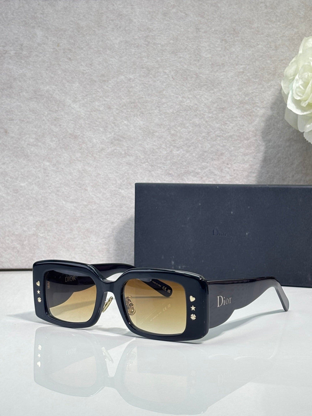 Dior rectangular sunglasses with amber-tinted lenses, navy frame with gold accents